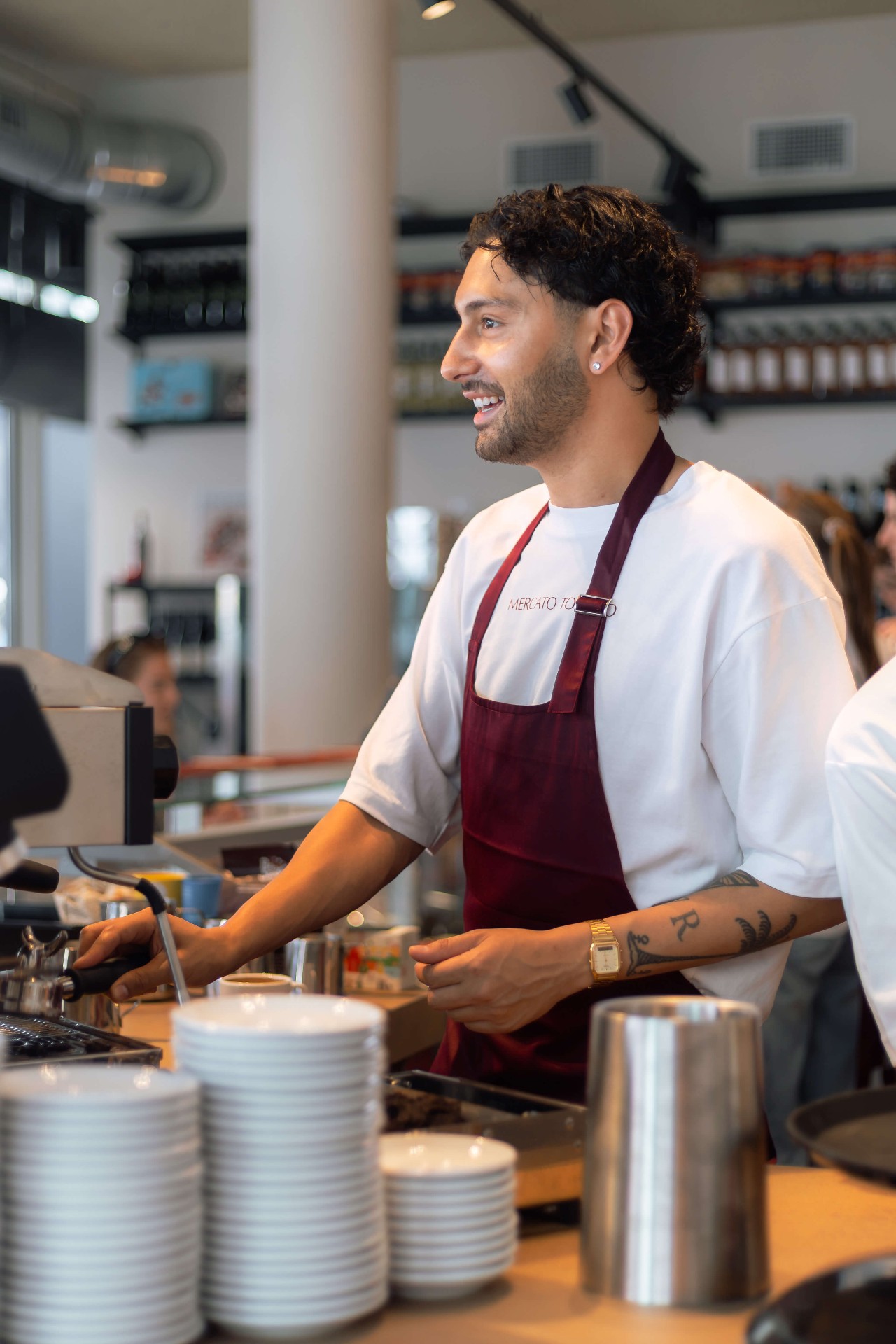 Barista achter de espressomachine tijdens de opening van Mercato Tomato