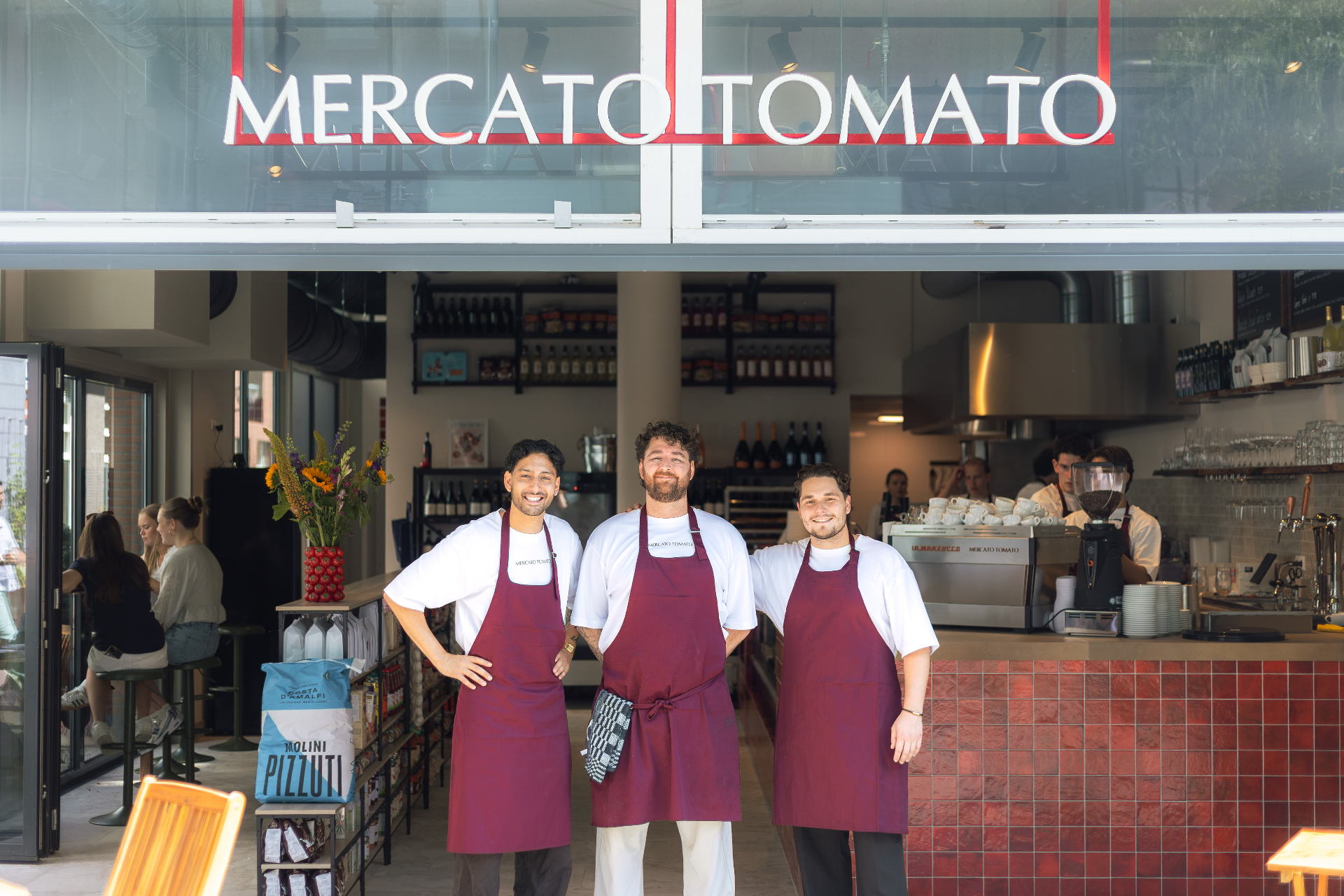 Het team van Mercato Tomato voor de gevel